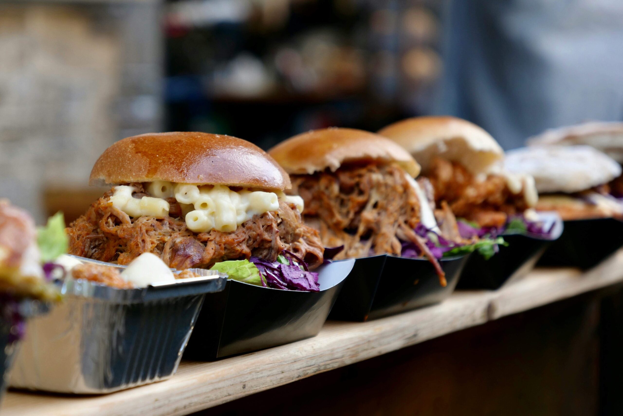 "Colorful street food and produce stalls at Borough Market, with people browsing and eating."