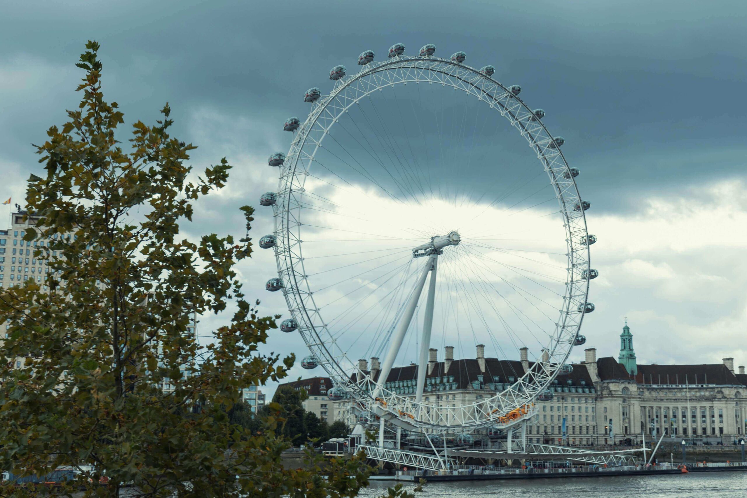 "The London Eye on the South Bank with surrounding modern and historic buildings along the River Thames."